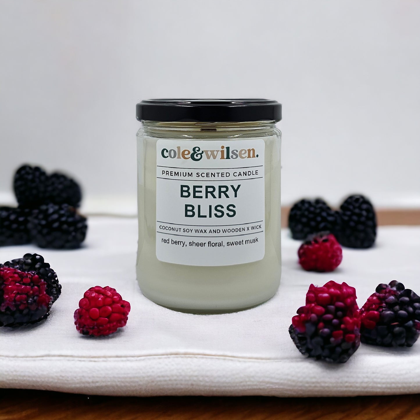 a jar of berry bliss surrounded by berries