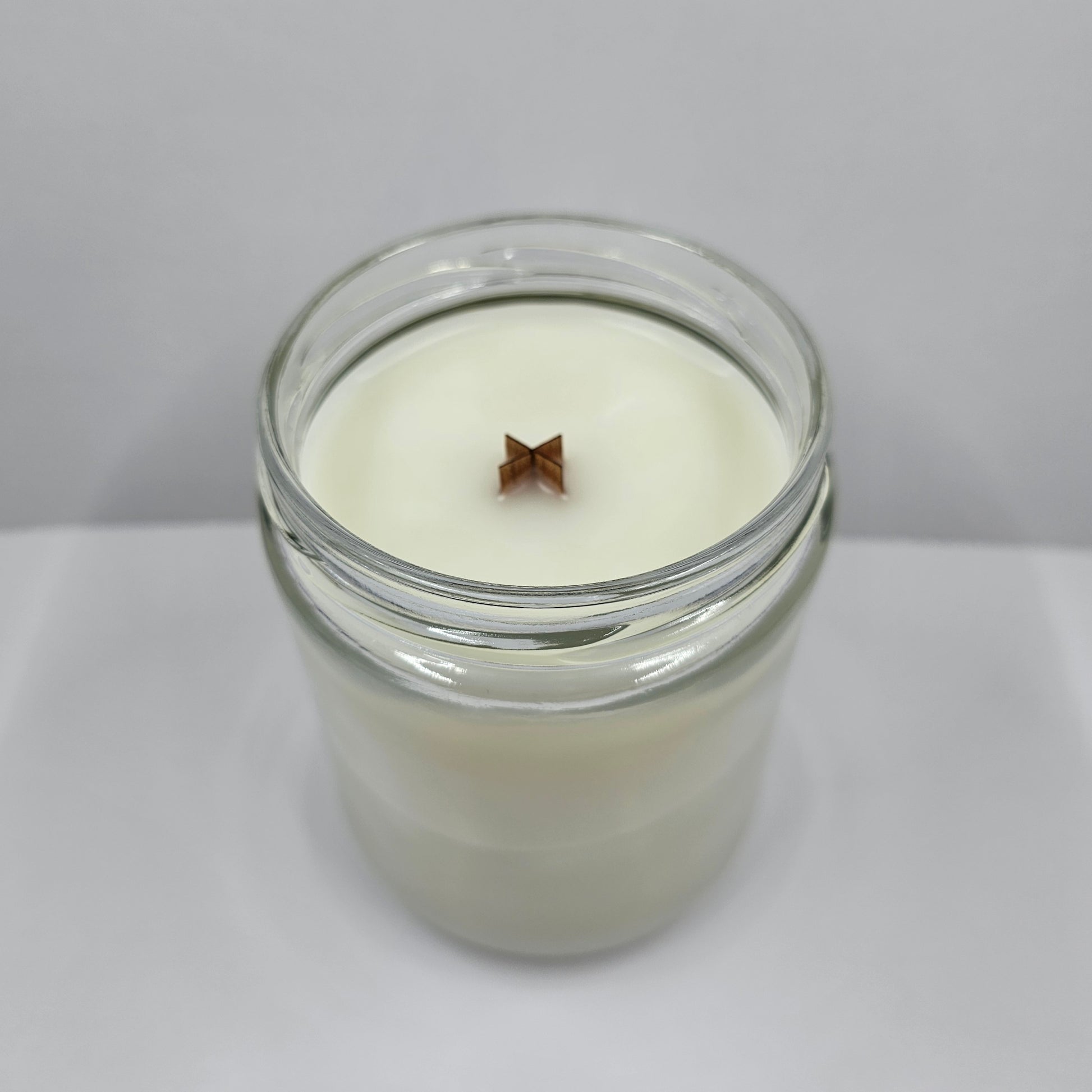 a glass jar filled with a white candle